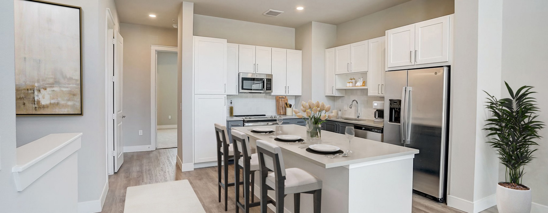 Spacious kitchen with white cabinets and stainless steel appliances